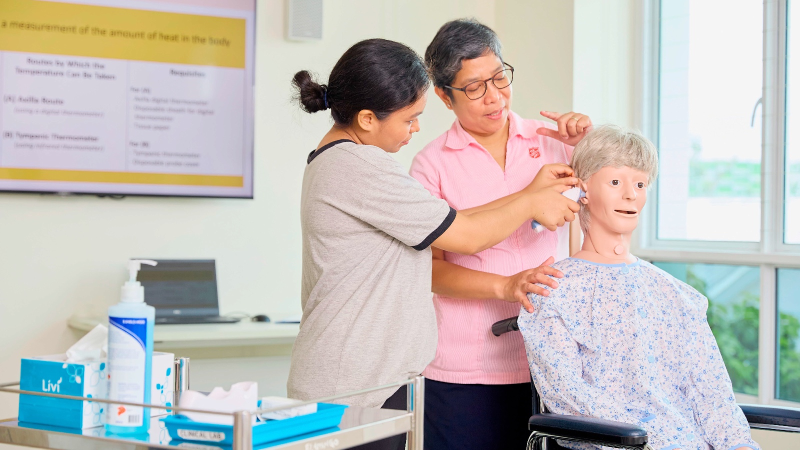 helper learning to take an elderly person's temperature