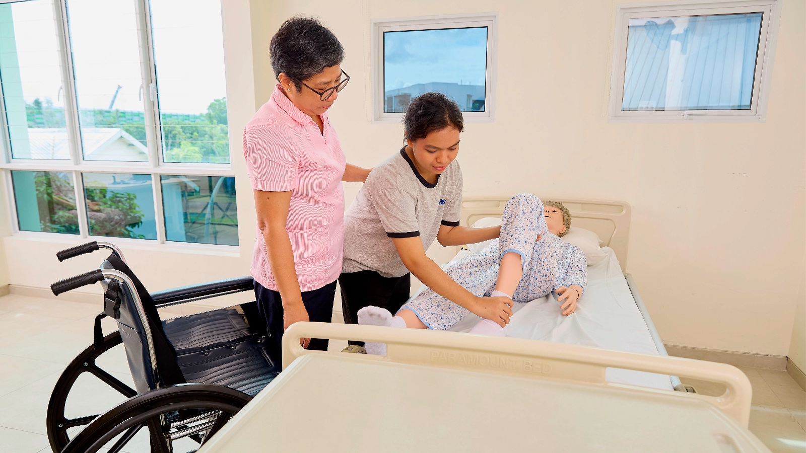 helper learning initial step in transferring elderly person from bed to wheelchair